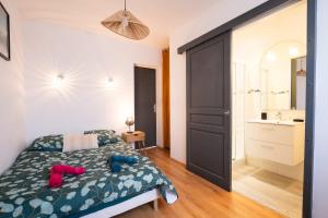 a bedroom with a bed with two slippers on it at Instant Pyrénéen in Lourdes