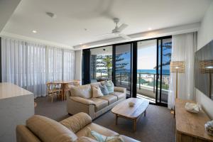a living room with a couch and a table at X Kirra Apartments in Gold Coast