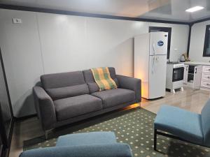 a living room with a couch and a kitchen at Mainumbi 1 in Balneario Solís