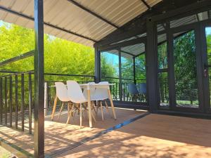 a screened porch with white chairs and a table at Mainumbi 1 in Balneario Solís