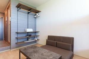 a living room with a couch and a table at コート エトワレ マエザト-新築アパートメントホテル- in Ishigaki Island