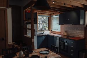 a kitchen with blue cabinets and a table and a window at Dibbin’s Chalet in Dinner Plain