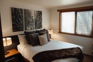 a bedroom with a bed with pillows and a window at Dibbin’s Chalet in Dinner Plain