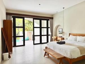 a bedroom with a large bed and sliding glass doors at Nazeki Villa in Uluwatu +33 photos