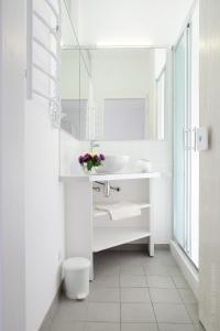 La salle de bains blanche est pourvue d'un lavabo et d'un miroir. dans l'établissement Hotel Black Cube, à Tripolʼye