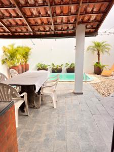 a patio with a table and chairs and a pool at Pousada Vivenza - Suíte 03 e 04 in Laguna