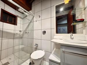 a bathroom with a toilet and a sink and a shower at Pousada Vivenza - Suíte 03 e 04 in Laguna +12 photos