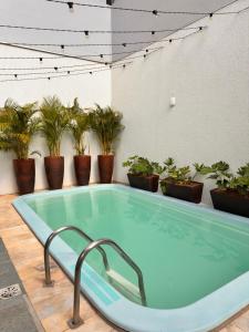 a hot tub in a room with potted plants at Pousada Vivenza - Suíte 03 e 04 in Laguna