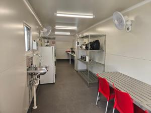 a room with red chairs and a table and a refrigerator at AAOK Riverdale Caravan Park in Bundaberg +9 photos