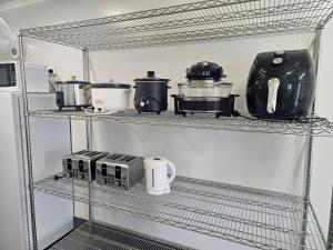 a kitchen shelf with various appliances on it at AAOK Riverdale Caravan Park in Bundaberg