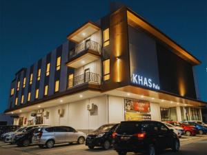 a building with cars parked in a parking lot at Khas Palu Hotel in Palu