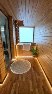 a sauna with a large window and a white rug at Casuta de la munte in Sărişor