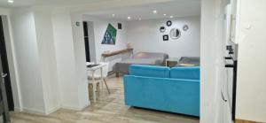 a living room with a blue couch and a bed at Apartament in Rybnik