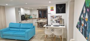 a living room with a blue chair and a kitchen at Apartament in Rybnik