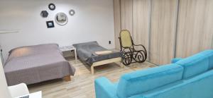a living room with a blue couch and a bed at Apartament in Rybnik