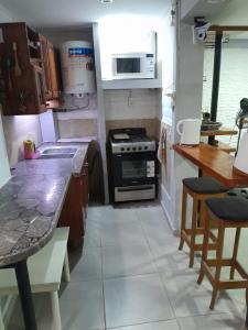 a kitchen with a stove and a counter top at Departamento b privado cerca arena Maipú p4 personas cochera in Maipú