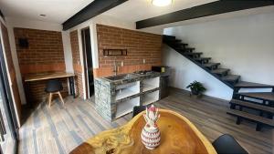 a living room with a table and a staircase at Cabañas Los Angeles in Valle de Bravo