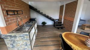 a kitchen with a sink and a brick wall at Cabañas Los Angeles in Valle de Bravo +2 photos