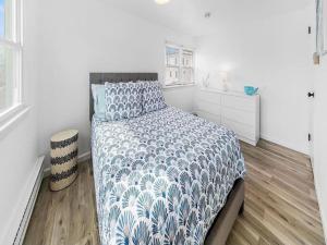 a bedroom with a bed with a blue and white comforter at Lbi - Ship Bottom, Duplex Available For Summer 2026 in Ship Bottom