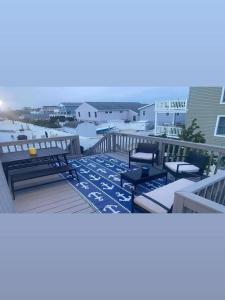 a deck with two benches and a picnic table on the beach at Lbi - Ship Bottom, Duplex Available For Summer 2026 in Ship Bottom