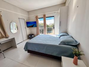 a bedroom with a bed and a large window at Pousada do Horto in Juazeiro do Norte