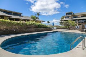 a swimming pool with blue water in front of a building at MA-1205 - Ocean Views AC in Koloa