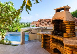 a brick oven sitting on top of a patio at Villa Caryota, Panorama Montagnes & Piscine 9m in Le Marin