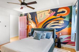 a bedroom with a bed with a painting on the wall at Once Upon A Tide in Bolivar Peninsula