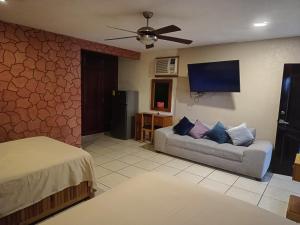 a living room with a couch and a flat screen tv at Hotel Tropigalas in Tampamachoco +1 photo
