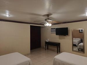 a room with two beds and a ceiling fan at Hotel Tropigalas in Tampamachoco