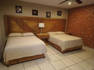 a bedroom with two beds in a room at Hotel Tropigalas in Tampamachoco