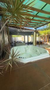 a jacuzzi tub in a building with palm trees at Casa pôr do Sol in Aracaju