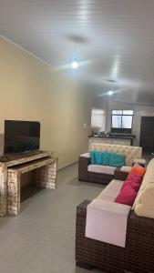 a living room with a piano and a couch at Casa pôr do Sol in Aracaju