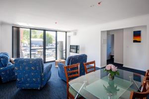 a living room with blue chairs and a glass table at 1 Duke street in Albany