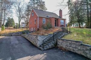 a red brick house with a stone wall at Pet Friendly Retreat Near Downtown Annapolis in Annapolis