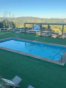 a large swimming pool with a chair and a table at CIRyT La Montaña - Eco Cabañas y Turismo Rural in Tomé