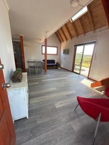 a living room with a red chair and a table at CIRyT La Montaña - Eco Cabañas y Turismo Rural in Tomé