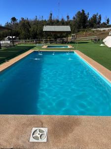 a large swimming pool with blue water in it at CIRyT La Montaña - Eco Cabañas y Turismo Rural in Tomé +19 photos