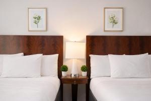 two beds in a hotel room with white pillows at Tilden Hotel Union Square in San Francisco