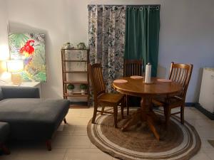 a living room with a wooden table and chairs at Manutapu Lodge in Tongatapu
