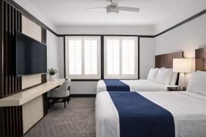 a hotel room with two beds and a flat screen tv at Tilden Hotel Union Square in San Francisco
