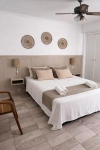 a bedroom with a large white bed with a ceiling at Hotel Ideal in Miramar