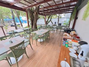 a restaurant with tables and chairs and a tree at Flat Premium no Centro de Porto de Galinhas - Próximo as piscinas naturais in Porto De Galinhas