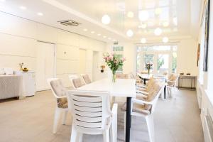 a dining room with a white table and chairs at Hotel Black Cube in Tripolʼye