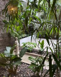 a statue in the middle of a garden with plants at Hotel Ideal in Miramar +8 photos