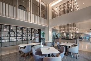 a restaurant with tables and chairs and chandeliers at Wanda Moments Beijing Pinggu in Pinggu