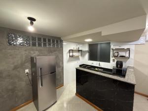 a kitchen with a stainless steel refrigerator in a room at Apartamento no Centro 2 Wi-Fi Garagem in Vacaria