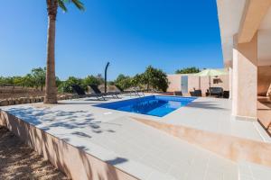 ein Swimmingpool neben einem Haus mit einer Palme in der Unterkunft Short De Son Fideu in El Estanyol