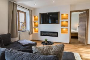 a living room with a couch and a fireplace at Hotel Garni Edelweiß in Siegsdorf