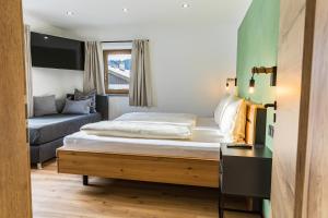 a small bedroom with a bed and a couch at Hotel Garni Edelweiß in Siegsdorf